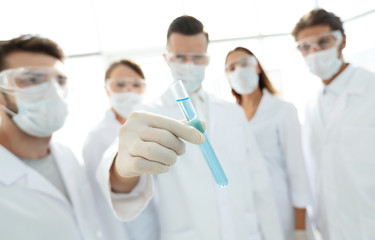 background image is a group of medical workers working with liquids in laboratory