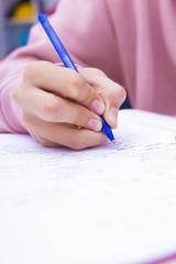 child's hand writing on the home desk or school