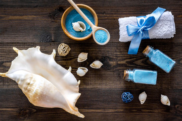 spa cosmetic set with sea salt for bath and shell on wooden background top view