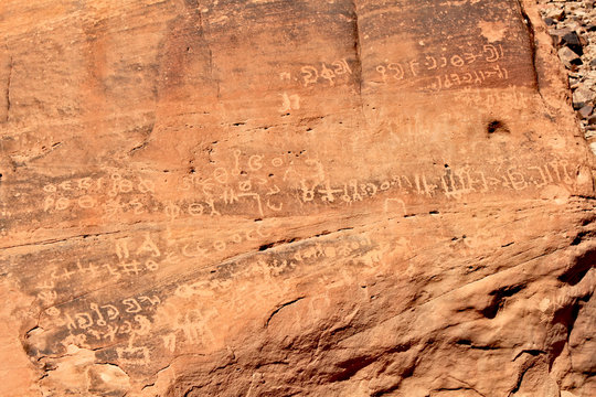 Inscription on red rocks in the valley on Wadi Rum desert in Jordan
