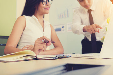 Young business woman looking at profits in a notebook and happy.