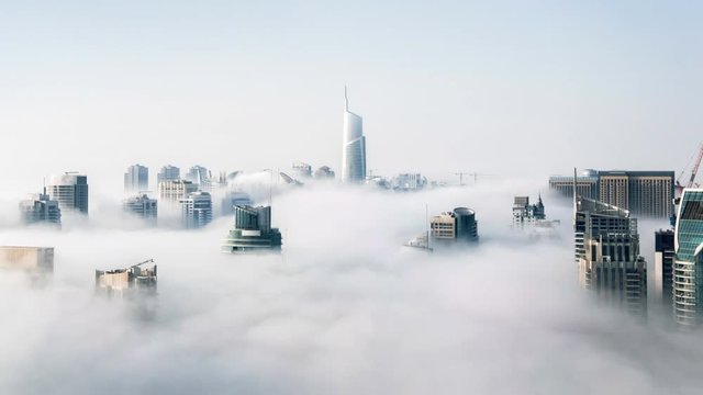 Cinemagraph of skyscrapers above the clouds in Hong Kong with clouds rolling through city in Asia