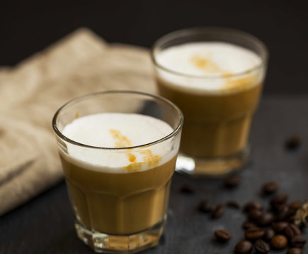 Espresso latte coffee glasses with milk foam and coffee beans , selective focus