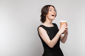 Picture of beautiful woman in black dress with coffe in hands