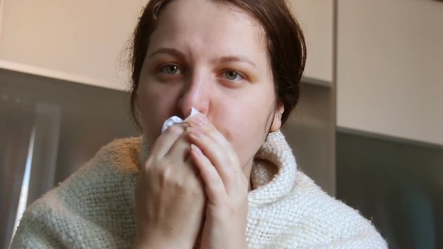 the woman gets sick with a nose. A thirty-year-old woman with a red for a cold had wrapped herself in a blanket. chills, acute respiratory viral infection, influenza. Real illing girl.