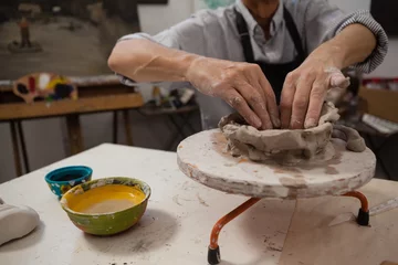 Foto op Canvas Mid-section of senior man molding clay © wavebreak3
