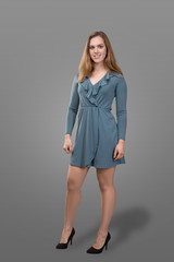 Young beautiful plus size model wearing in blue dress, xl woman on gray studio background