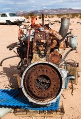 old rusting car engine in a desert junkyard