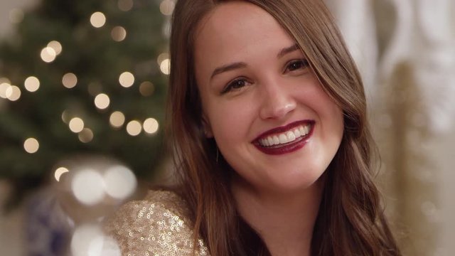 Close Up Handheld Shot Of A Woman Talking And Smiling At A Decorated Holiday Party