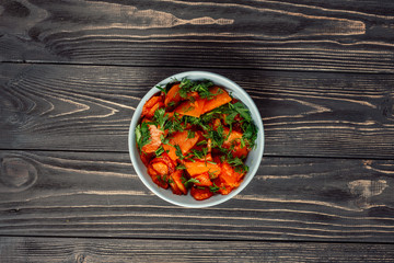 cooked fried pumpkin in a bowl on a wooden gray background texture