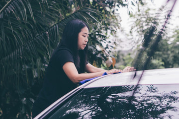 Asian woman washing car roof with microfiber cloth., instagram picture.