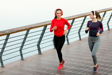 Young women running by the river in the morning