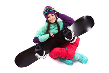 young woman in purple ski outfit hold snowboard on knees