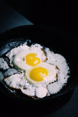 fried eggs in a frying pan with sour cream sauce