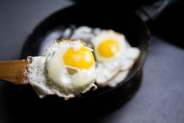 fried egg on a wooden spatula, cooking at home