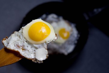 fried egg on a wooden spatula, cooking at home