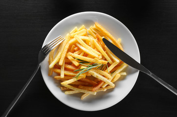 Plate with yummy french fries on table