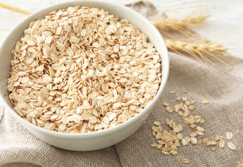 Bowl with raw oatmeal on table