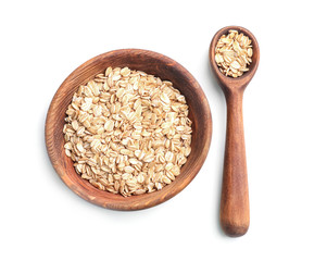 Plate with raw oatmeal and spoon on white background