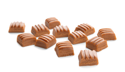 Sweet caramel candies on white background