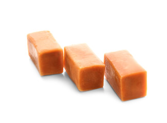 Sweet caramel candies on white background
