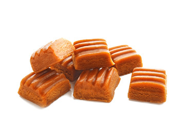Sweet caramel candies on white background