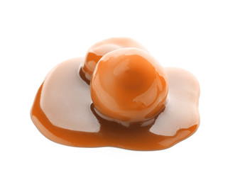 Sweet candies with caramel topping on white background