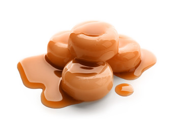 Sweet candies with caramel topping on white background