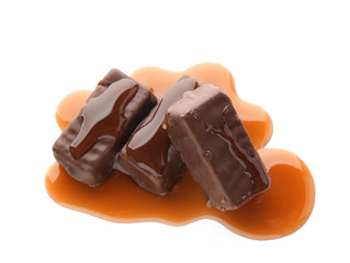 Sweet chocolate candies with caramel topping on white background