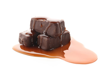 Sweet chocolate candies with caramel topping on white background