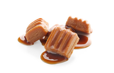Sweet candies with caramel topping on white background