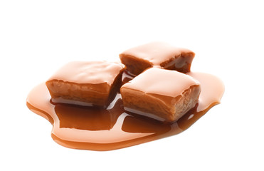 Sweet candies with caramel topping on white background