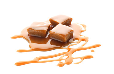 Sweet candies with caramel topping on white background