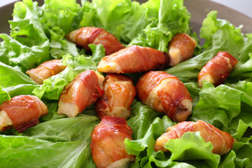 Bacon wrapped chicken on lettuce, closeup
