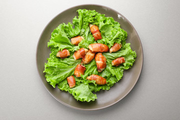 Plate with bacon wrapped chicken on table