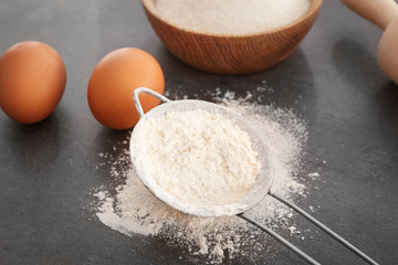 Sieve with flour on gray table