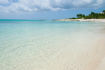 Turquoise sea water with white sand beach and blue sky. Turks and Caicos Islands.
