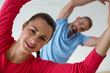 Portrait of female student exercising with instructor in health