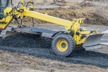 Motor grader with a blade performs the layout of a road crushed stone gravel base