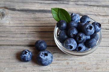 Fresh organic blueberries in a glass bowl on old wooden background.Blueberry.
Bilberries.Healthy eating,vegan food,diet and nutrition concept.Selective focus.
