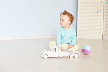 child plays with a car in the studio