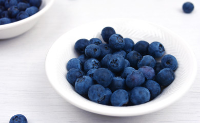 Freshly picked blueberries in a white bowl.