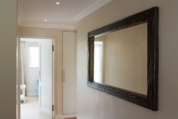  Wooden framed mirror on white wall