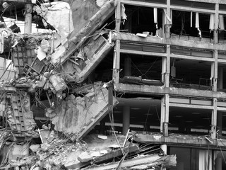 collapsing destroyed large concrete building with smashed ruined floors and pillars awaiting demolition