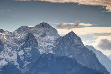 Mighty Triglav peak, highest point of Slovenia, towering above crags of Vrbanova spica, Begunjski vrh and Cmir peaks covered with snow in a sunny autumn day, Triglav National Park, Julian Alps, Europe