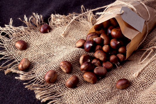 edible chestnuts - a bag of fresh, raw chestnuts sprinkled on the table