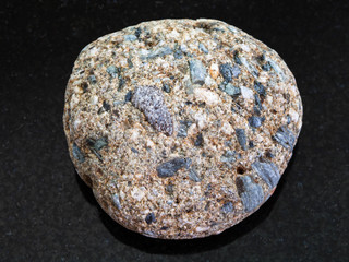 pebble of Arkose sandstone on dark background