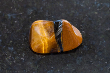 polished tiger eye gemstone on dark background