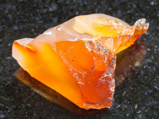 rough Carnelian (chalcedony) gemstone on dark