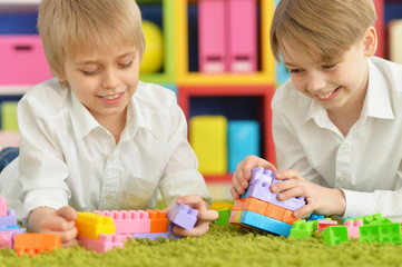boys playing with colorful plastic blocks 
